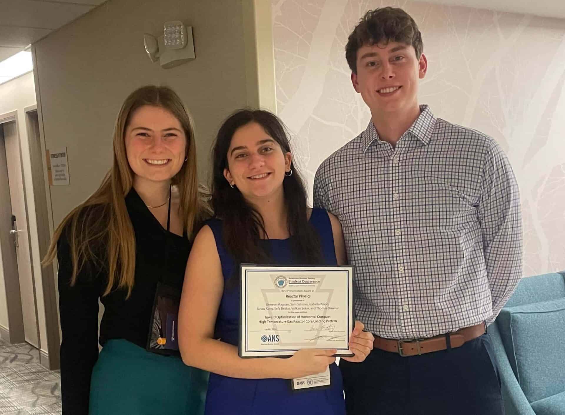 three students holding an award